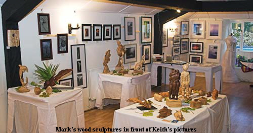 Mark's wood sculptures in front of Keith's pictures